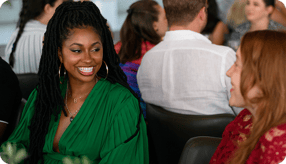 Two female students from the Indiana University Kelley Direct Online MBA exchange glances in the foreground with other students in the background.